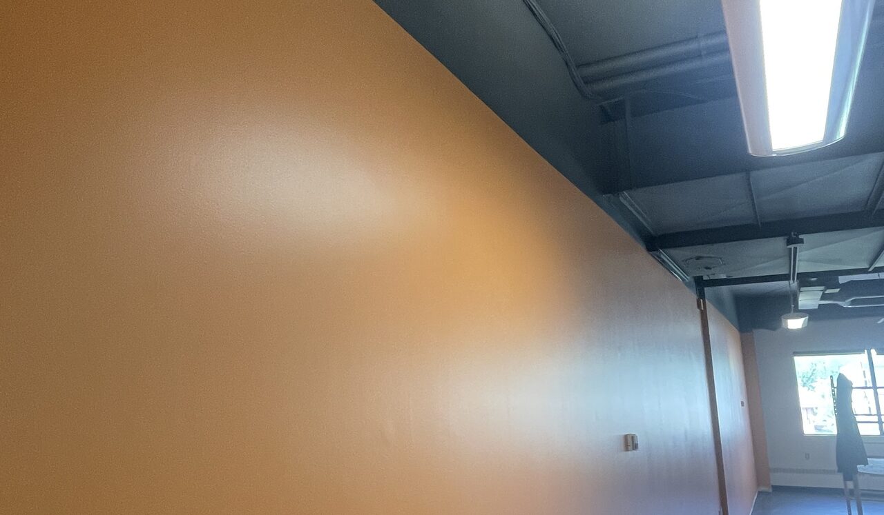 Wall cut in sharp against a black exposed ceiling in a Calgary commercial repaint