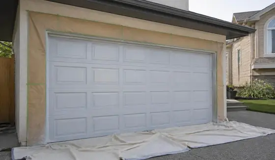Garage door masked with film and tape, primed and ready for its finish coats