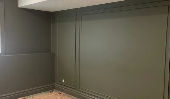 Calgary room painted olive green with matching wall panelling, trim and baseboards